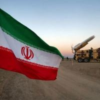 Bandeira do Irã perto de míssil durante exercício militar