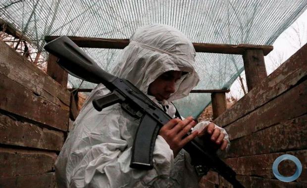 Um militante da autoproclamada República Popular de Donetsk (DNR) segura uma arma em posições de combate na linha de separação das forças armadas ucranianas perto do assentamento controlado pelos rebeldes de Yasne (Yasnoye) na região de Donetsk, Ucrânia 14 de janeiro de 2022