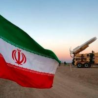 Bandeira do Irã perto de míssil durante exercício milita